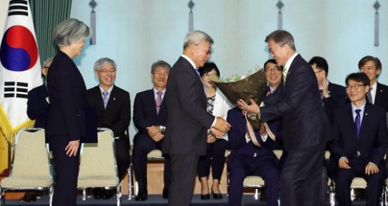 문재인 대통령이 2017년 6월 18일 오후 청와대에서 열린 강경화 외교부장관 임명식에서 강 장관의 배우자인 이일병 교수에게 꽃다발을 주고 있다.