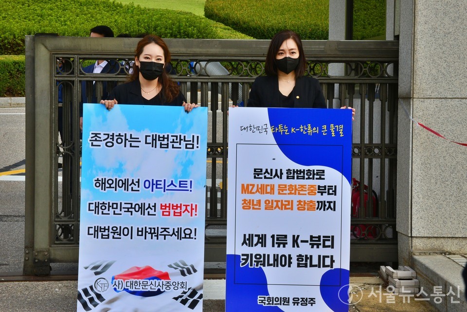 (사)대한문신사중앙회와 관련 단체 소속 문신사들이 27일 서울 서초동 대법원 앞에서 '문신은 의료 행위가 아니다' 라며 대법원의 무죄판결을 촉구하는 1인 릴레이 시위를 진행했다. 이날 문체위 소속 유정주 국회의원도 1인 시위에 참여, 타투 합법화를 위한 공동발의에 나섰다. 사진은 유정주 국회의원(오른쪽)과 (사)대한문신사중앙회 임보란 회장. (사진 = 이민희 기자) 