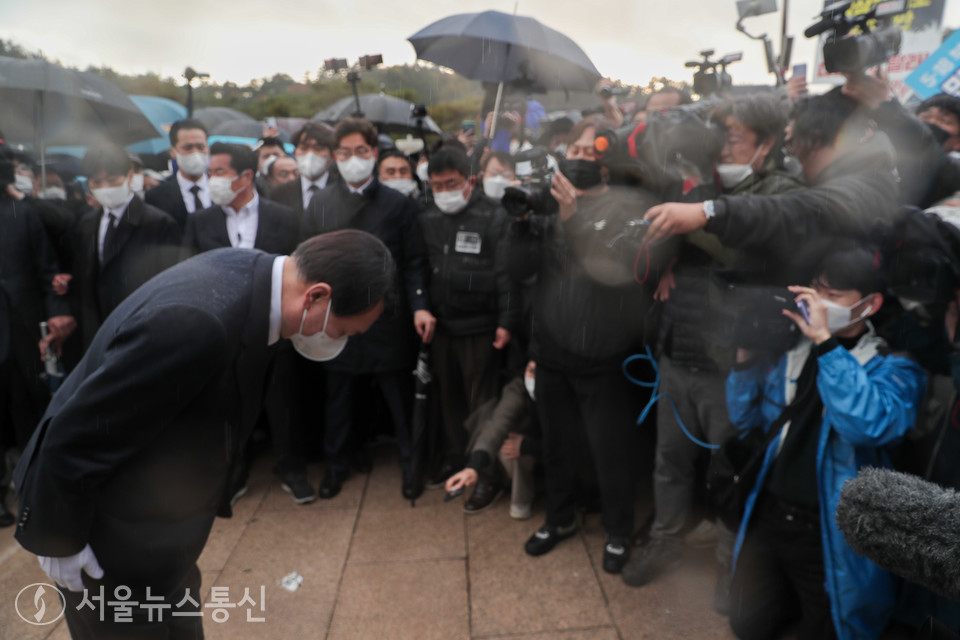 국민의힘 윤석열 대선후보가 10일 광주 북구 5·18 민주묘지에서 항의하는 시민들에게 막혀 추모탑에 분향하지 못하고 비를 맞으며 광장에서 묵념으로 참배했다. 