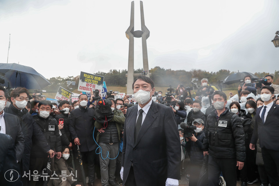 국민의힘 윤석열 대선후보가 10일 광주 북구 5·18 민주묘지에서 항의하는 시민들에게 막혀 추모탑에 분향하지 못하고 비를 맞으며 광장에서 묵념으로 참배했다. 