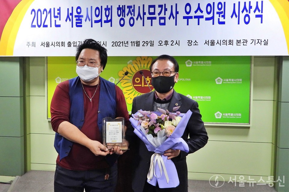 서울시의회 출입기자단은 29일 '서울시의회 2021년 행정사무감사 우수의원'을 선정, 시상식을 갖고 수상 의원들을 축하했다. 사진은 서울뉴스통신 이민희 기자가 문화체육관광위 이종환 시의원에게 시상후 기념촬영하고 있다. (사진 = 서울시의회 출입기자단) 