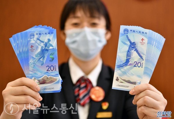 21일 중국공상은행 베이징 시커잔(西客站) 지행의 직원이 제24회 동계올림픽 기념지폐를 보여주고 있다. / 사진=신화통신