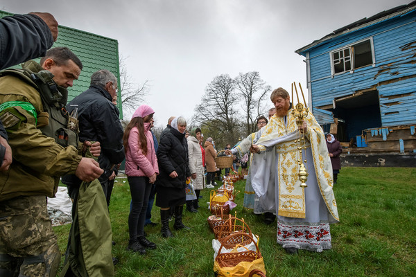 4월 24일 우크라이나 페레모하 마을에서 정교회 사제가 포격으로 피해를 입은 성모 마리아 교회 옆에서 열린 예배 과정에 성수를 뿌리고 있다/CNN