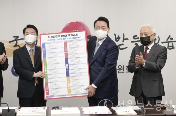 윤석열 대통령 당선인이 3일 오전 서울 종로구 삼청동 인수위원회 대회의실에서 개최된 '제8차 인수위원회 전체회의'에서 안철수 인수위원장에게 '윤석열 정부 110대 국정과제'를 전달 받고 기념 촬영을 하고 있다. 2022.5.3/사진=인수위 대변인실 제공