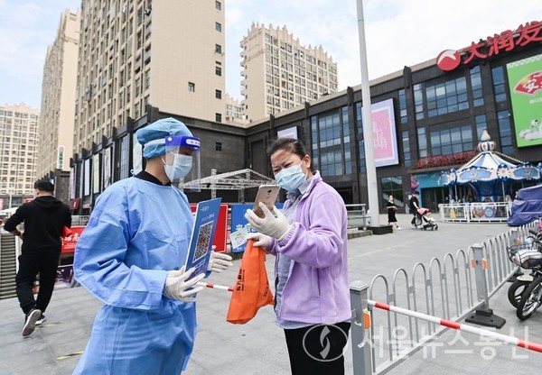 중국 상하이 자딩구의 한 슈퍼마켓 입구에서 한 주민이 자신의 건강 코드를 확인하고 있다. 2022.5.9/신화통신