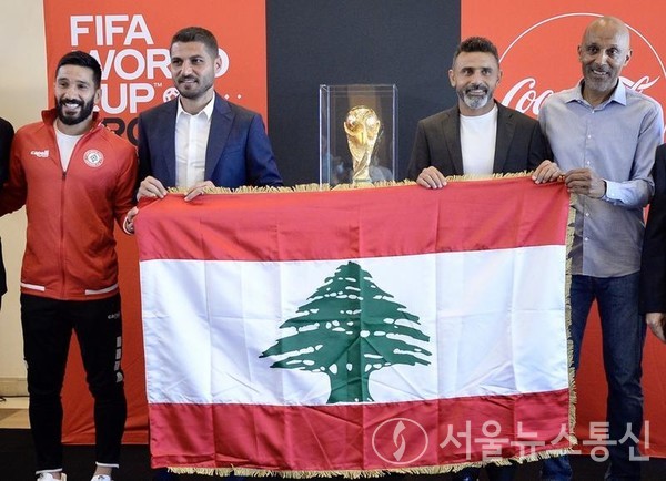 레바논의 스포츠 스타들과 팬들이 5일 레바논 베이루트 공항에서 FIFA 월드컵 트로피를 들고 포즈를 취하고 있다. 2022.6.5/신화통신