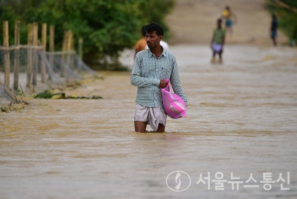 18일 인도 동북부 아삼주, 메갈라야주에서 연일 폭우가 쏟아져 지난 이틀간 최소 32명이 숨졌다. 사진은 인도 아삼주의 한 마을에서 주민들이 침수된 도로를 걷고 있다. 2022.6.18/사진=/신화통신