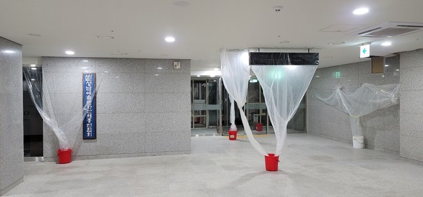 신축된지 얼마되지도 않는 아트리움 공연장 지하에 빗물이 스며들면서 천정에 물이 떨어지자 비닐로 물을 한데 모아 물받이 통에 담아내고 있는 광경. 사진/김대운 기자  