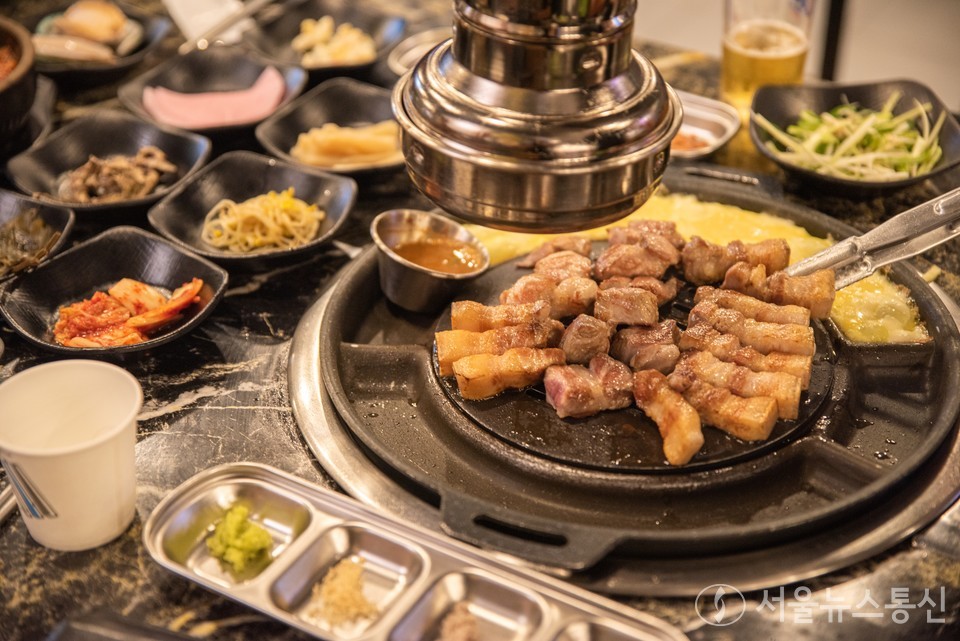 숯불흑돼지 한판. 잘 구어진 흑돼지 고기를 칼칼한 제주식 소스에 찍어 먹으면 식감이 일품이다. 