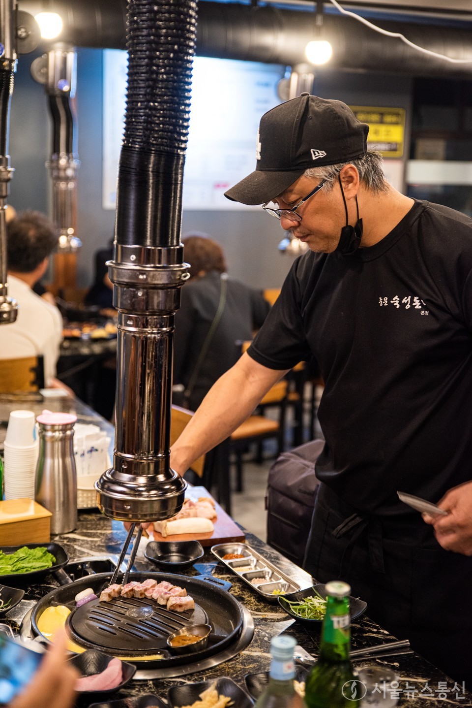 제주 중문숙성돈가 본점 최광욱 대표가 숯불흑돼지를 굽고 있다. 