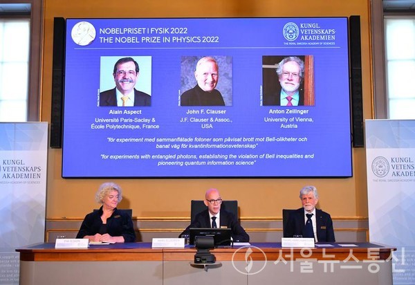 4일 스웨덴 스톡홀름에서 열린 2022년 노벨 물리학상 발표 현장에 수상자인 알랭 아스페(왼쪽), 존 클라우저(가운데), 안톤 차일링거의 모습이 스크린에 비치고 있다. (사진/신화통신)