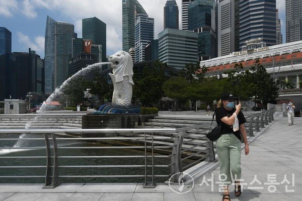 마스크를 쓴 한 관광객이 24일 싱가포르 머라이언 공원을 거닐고 있다. 2022.3.24/신화통신