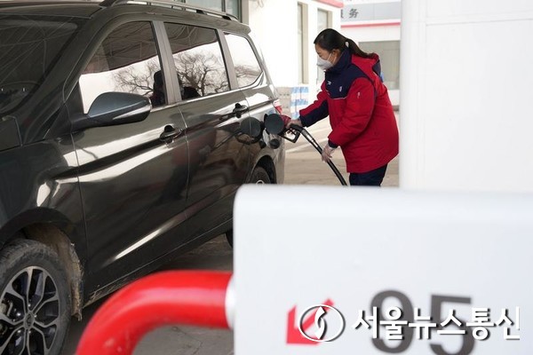 한 직원이 17일 중국 북부 허베이성 싱타이의 렌제 구에 있는 주유소에서 차에 연료를 주입하고 있다. 2023.1.17/신화통신