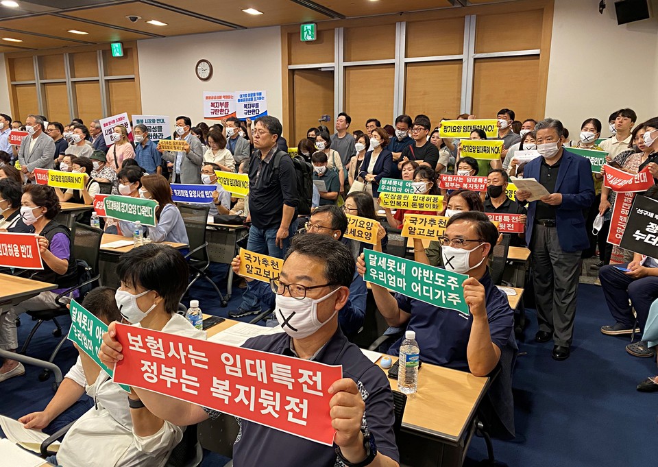 한국노인복지중앙회장(사진 가운데)이 지난 19일 서울 중구 대한상공회의소에서 열린 '신 노년층 요양시설 서비스 활성화 방안 연구 관련 공청회'에서 '국가추천 장기요양, 알고보니 월세요양'이라는 팻말을 들고 침묵시위를 하고 있다. (한국노인복지중앙회 사진제공)