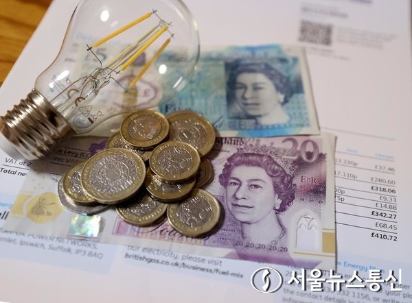 지난해 10월 7일 영국 런던의 한 가정에서 촬영한 전기세 청구서와 파운드 일부. (사진/신화통신)