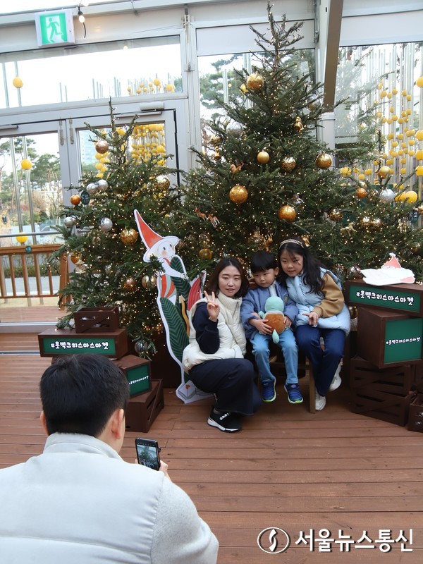 27일 서울 잠실에 장식된 크리스마스 트리에서 한 가족이 스마트폰으로 사진 촬영을 하고 있다. (2023.11.27) / 사진 = 서울뉴스통신 이성현 기자