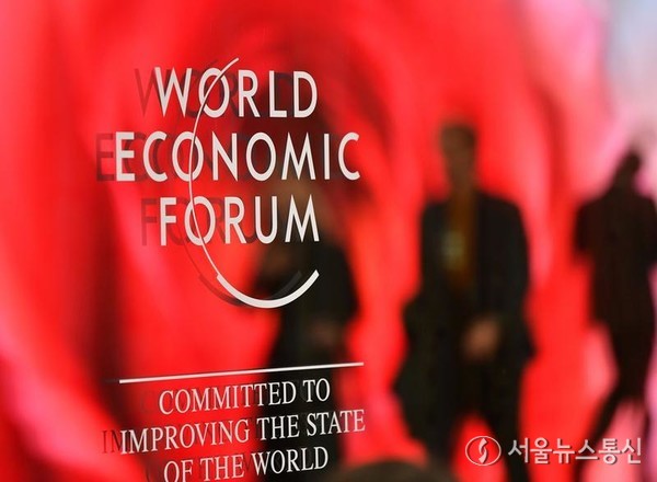 15일 스위스 다보스에서 열린 세계경제포럼(WEF) 로고를 참가자들이 지나가고 있다. 2024.1.15/신화=서울뉴스통신