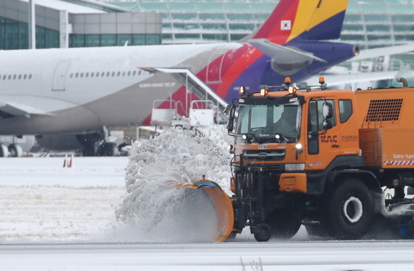 북극 한파 영향으로 전국 기상이 악화한 21일 오후 제주국제공항 활주로에서 제설차량들이 부지런히 쌓인 눈을 치우고 있다. (2023.12.21)
