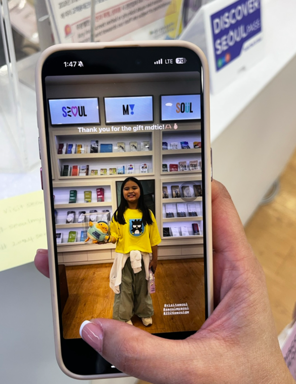 가족여행으로 서울을 방문한 관광객들이 명동관광정보센터에서 ‘서울 마이 소울’ 브랜드 사진 촬영 후 이벤트 참여 인증을 하고 있다. 