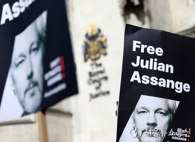 26일 영국 런던 고등법원 밖에서 지지자들이 '어산지를 석방하라'고 쓰인 피켓을 들고 시위를 벌이고 있다. 2024.3.26/신화=서울뉴스통신