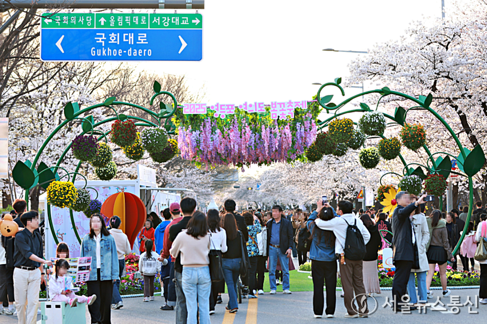 서울 영등포구가 여의도 봄꽃축제를 맞아 지역경제 활성화를 위한 ‘봄꽃 할인 행사’를 진행한다.  사진은 9일 2025 여의도 봄꽃축제에서 상춘객들이 활짝 핀 벚꽃길을 걷고 있다. (2025.04.09) / 사진 = 서울뉴스통신 황수연 기자