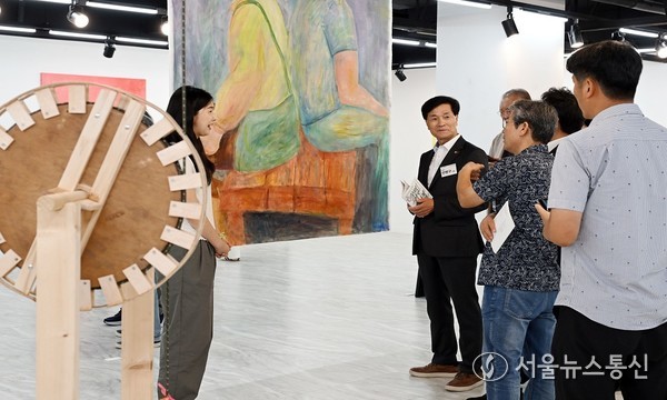 14일 밀양문화원에서 열린‘2025 아트성수 프리뷰: 헬로! 밀양_우리 서로 만나게 된다면’ 전시 오픈 행사 참석자들이 작품 설명을 듣고 있다.