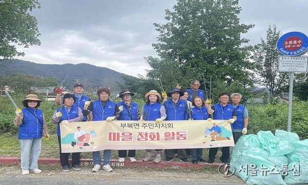 밀양시 부북면 주민자치회 위원들이 플로깅 행사를 마치고 단체 기념 촬영을 하고 있다.