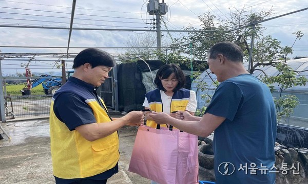 안선미 밀양시 하남읍장(가운데)과 김태석 하남읍 지역사회보장협의체 민간위원장(왼쪽)이 1인 가구를 직접 방문해 행복 보따리를 전달하고 있다.
