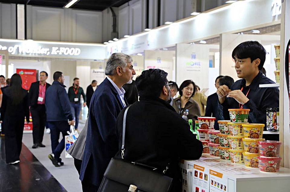 농림축산식품부가 마련한 한국관에서 현지 소비자들이 떡볶이에 대한 제품 설명을 듣고 있다. (2025.10.21) / 사진 = 농식품부 제공