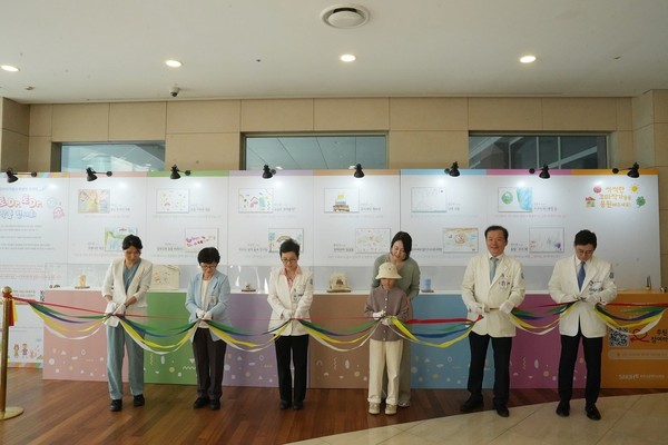 분당서울대병원이 지난 17일 병원 1층 1동-2동 연결부에서 ‘토Dr.토Dr.(토닥토닥)’ 소아청소년 환아 작품 전시회 개막식을 갖고 전시회를 개최하고 있어 주목받고 있다. 사진은 개막식에서 병원관계자 및 지도작가, 소아환자(사진 중앙)와 함께 개막식 커팅을 하고 있느 모습. 사진/분당서울대병원