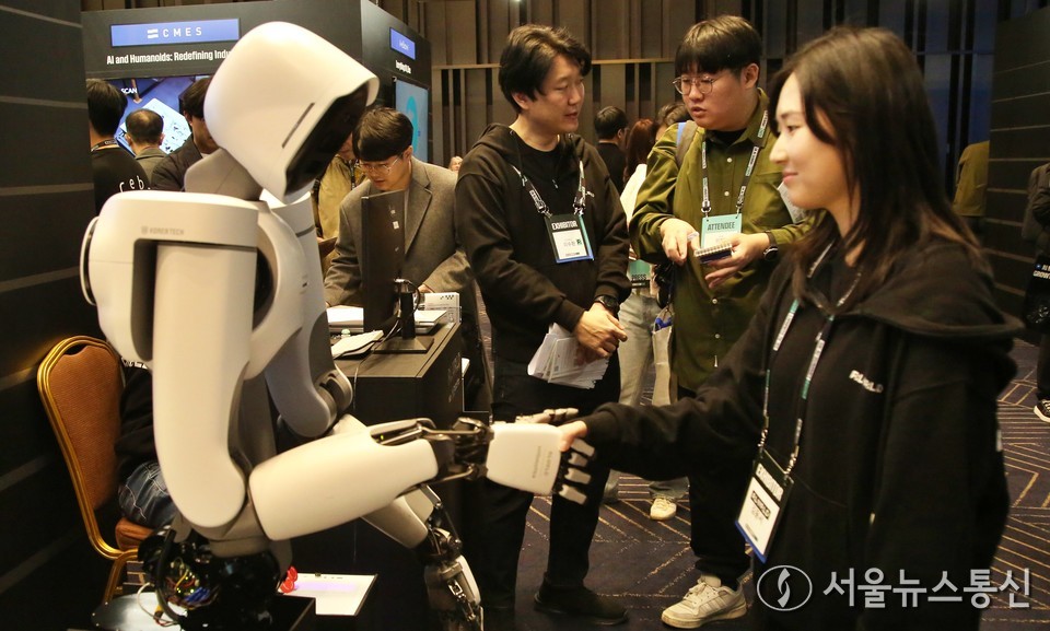  3일 서울 강남구 코엑스에서 열린 'SK AI 서밋(SUMMIT) 2025'에서 관계자가 로봇과 악수를 시연하고 있다. 2025.11.03, snakorea.rc@gmail.com , *재판매 및 DB 금지