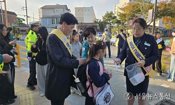 안병구 밀양시장이 5일 밀주초등학교 앞에서 열린 교통안전 캠페인 행사에서 학생들에게 이름표를 달아주고 있다.