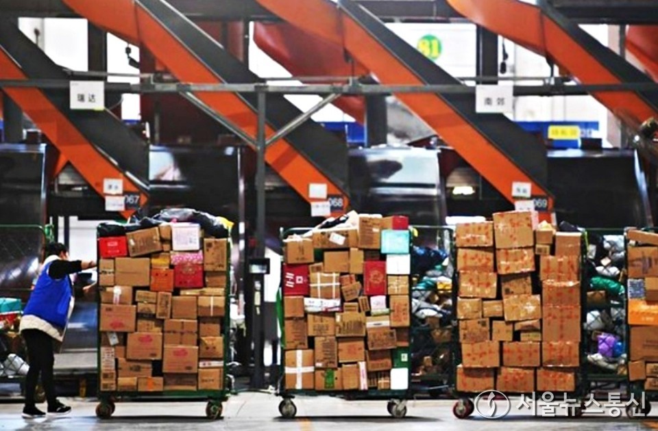 지난해 11월 11일 허난(河南)성 정저우(鄭州)시의 한 물류센터에서 직원이 택배를 옮기고 있다. / 사진 = 신화통신